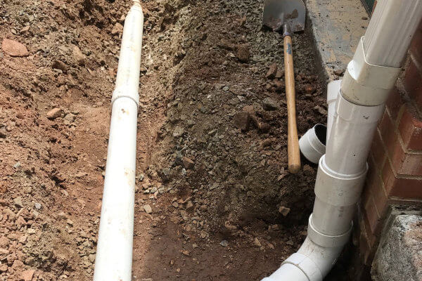 Underground PVC Pipes Connected to Downspouts